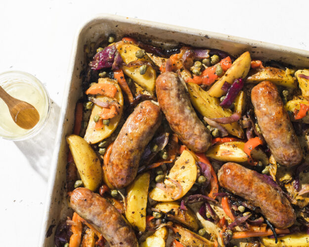 Roast Italian sausages over potatoes and peppers for a flavorful one-pan supper